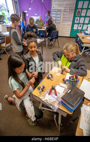 Les enfants de l'école élémentaire multiraciale enthousiaste assemblage robots comme un projet de classe à Mission Viejo, CA. Banque D'Images