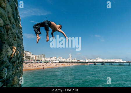 Boy diving dans la mer sur la plage de Brighton Banque D'Images