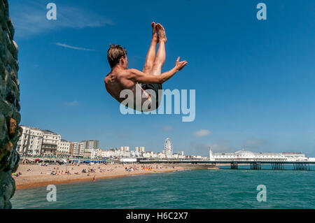 Boy diving dans la mer sur la plage de Brighton Banque D'Images