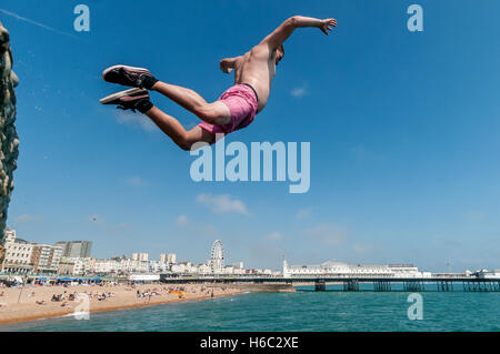 Boy diving dans la mer sur la plage de Brighton Banque D'Images