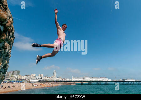 Boy diving dans la mer sur la plage de Brighton Banque D'Images