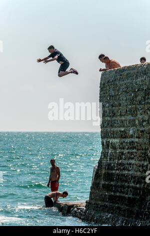 Boy diving dans la mer sur la plage de Brighton Banque D'Images