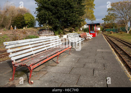 Feuilles d'automne, banc vide sur les voies de la gare du chemin de fer miniature inutilisé et négligé Lakeside, Southport, Merseyside, Royaume-Uni Banque D'Images