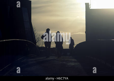 Silhouette d'un couple homme et d'une femme parlant au Glasgow street avec road cont- jour surlignée en Glasgow, Écosse, Royaume-Uni. Banque D'Images