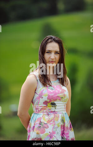 Brunette girl enjoying voyage dans les montagnes. Young smiling woman wearing dress voyageant dans la campagne Banque D'Images