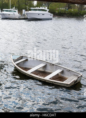 Petit bateau naufrage avec de l'eau à l'intérieur d'un magnifique bateaux modernes. Banque D'Images