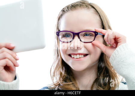 Close up Portrait of Girl à miroir en essayant de nouvelles lunettes.isolé sur fond blanc. Banque D'Images