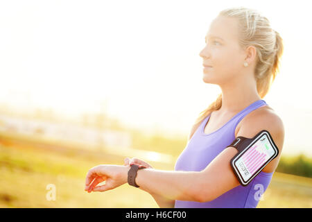 Close up portrait of attractive young woman création d'entraînement sur smart watch.Girl in sport wear avec remise en forme graphique. Banque D'Images