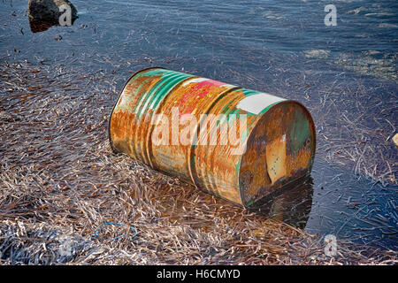 Rusty baril de pétrole près de la rive de la mer. Banque D'Images