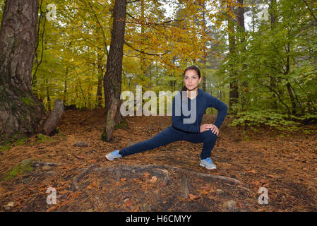 Jeune femme énergique de faire les exercices en plein air dans le parc de garder leur corps en forme. Concept de remise en forme. Thème de body-building. M Sport Banque D'Images