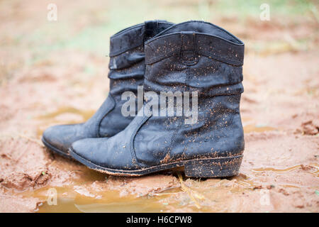 Cowgirl bottes dans la boue Banque D'Images