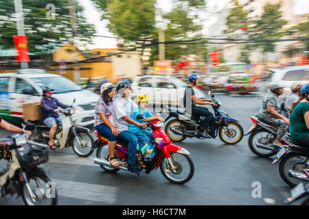 Famille sur un scooter dans la circulation lourde, motion blur, Ho Chi Minh City, Vietnam Banque D'Images