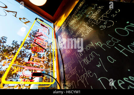 Vue grand angle d'un menu à la main sur un tableau noir dans un café. Banque D'Images