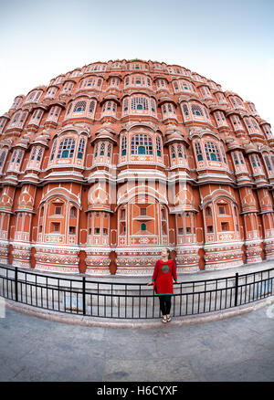 Femme en robe rouge avec écharpe debout près de façade de Hawa Mahal, Rajasthan, Inde Banque D'Images