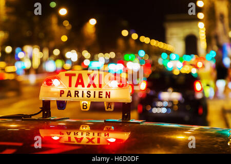 L'enseigne au néon d'un taxi parisien sur les Champs-Elysées dans la nuit Banque D'Images
