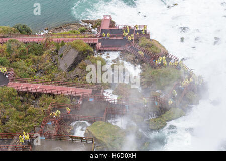 Les touristes sont couverts avec des chutes tout en faisant l'expérience de la Grotte des vents attraction dans Niagara Falls, New York. Banque D'Images