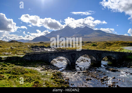 Vieux de trois fenêtres cintrées pont de pierre sur la rivière Sligachan Ile de Skye en Ecosse avec montagnes Cuillin dans la distance Banque D'Images