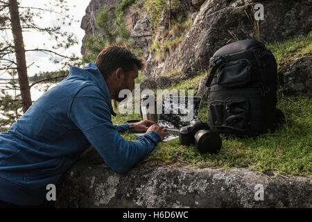 L'homme n'a son bureau dans la forêt sur la pierre Banque D'Images