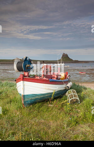 Coble traditionnels bateaux de pêche en vue de château de Lindisfarne, Holy Island, Northumberland, Angleterre Banque D'Images