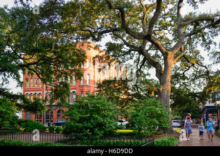 Famille bénéficie de la promenade près de Savannah College of Art and Design de style néo-romane de Posetter Hall voilé de grands arbres Banque D'Images