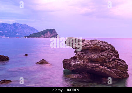 La seascape violet à partir de la côte rocheuse avec l'île de Sveti Nikola sur l'arrière-plan, Budva, Monténégro. Banque D'Images