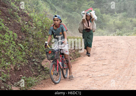 Garçon à vélo et femme âgée transportant des marchandises, village de Ban Phavie, peuple Khmu/Khamu, près de Muang la, province d'Oudomxay, Laos Banque D'Images