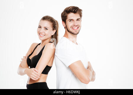 Portrait d'un couple standing standing back to back with arms folded isolé sur fond blanc Banque D'Images