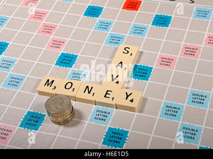 Scrabble board et tuiles affaires de finances personnelles économiser des économies économiser de l'argent concept Angleterre Royaume-Uni GB Grande-Bretagne Banque D'Images
