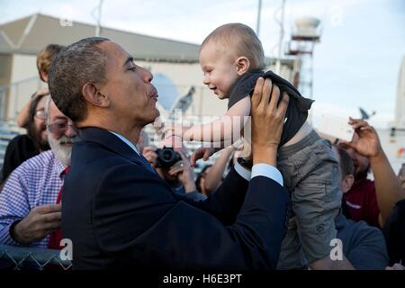 Le président des États-Unis, Barack Obama, est titulaire d'un bébé pendant que saluer les gens sur le tarmac à l'arrivée à l'Aéroport International de San Francisco, 12 février 2015 à San Francisco, Californie. Banque D'Images