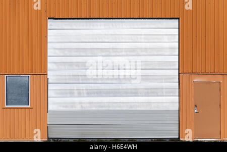 Mur d'entrepôt métallique rouge avec porte fermée, porte et fenêtre, télévision la texture de fond photo Banque D'Images