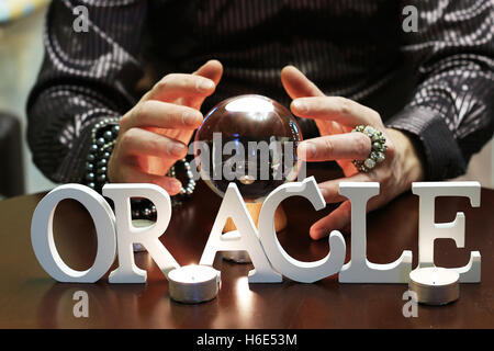 Les mains du sorcier sur une boule de cristal transparente la divination pour les futures Banque D'Images