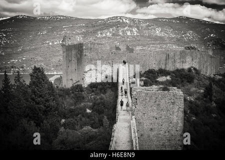 Les touristes sur le grand mur au-dessus de Mali Ston, Ston, côte dalmate, en Croatie Banque D'Images