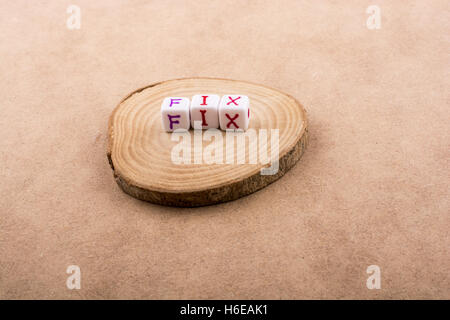 Lettre de l'alphabet coloré cubes dans un morceau en bois Banque D'Images