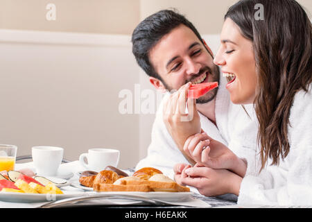 Relations sérieuses in Close up portrait of couple en peignoir sur le lit appréciant leur petit-déjeuner ensemble. Banque D'Images