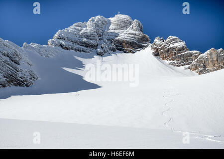 Une piste de ski mène de l'avant-plan vers le haut d'une montagne rocheuse sur une journée ensoleillée. Banque D'Images