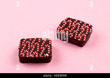 Chocolats de Noël faits à la main, saveur de canne à sucre, sur fond rose Banque D'Images