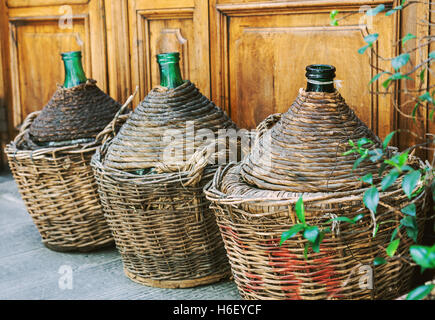 Vintage osier vide des bouteilles de vin en Toscane, Italie Banque D'Images