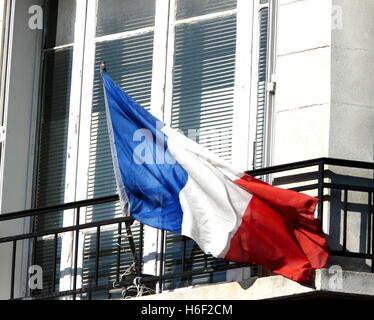 Brandir le drapeau français dans le vent sur une journée ensoleillée, sur un balcon à Montmartre, Paris. Banque D'Images