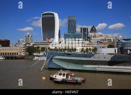 La proue du HMS Belfast, sur la Tamise, avec les gratte-ciel de talkie-walkie et d'autres bâtiments dans la ville de Londres derrière. Banque D'Images