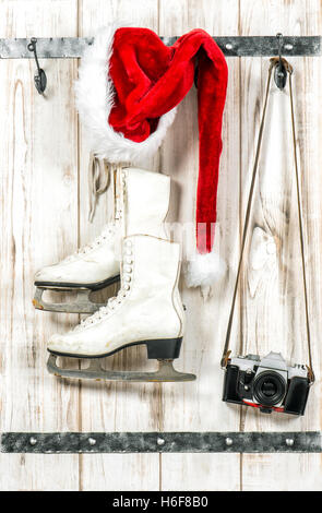 Décoration de Noël. Santas Red hat, vintage photo caméra et patins à glace blanc Banque D'Images