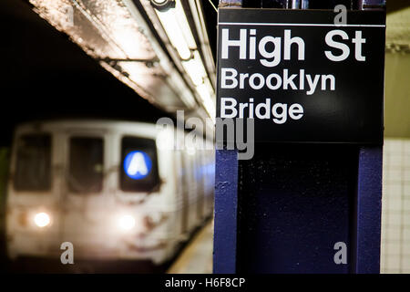 Subway train approchant derrière l'enseigne représentant c'est la High Street station Pont de Brooklyn de Brooklyn, New York. Banque D'Images