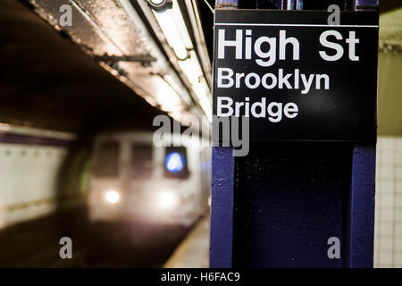 Subway train approchant derrière l'enseigne représentant c'est la High Street station Pont de Brooklyn de Brooklyn, New York. Banque D'Images