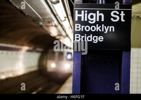 Subway train approchant derrière l'enseigne représentant c'est la High Street station Pont de Brooklyn de Brooklyn, New York. Banque D'Images