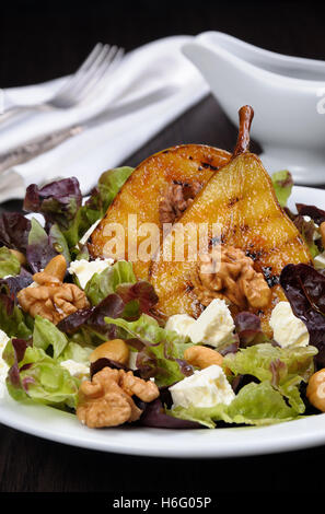 Salade de laitue aux noix, noix de cajou, tranches de fromage feta, les moitiés de poire caramélisée Banque D'Images
