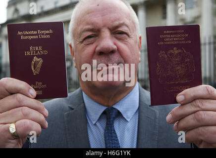 Raymond McCord contient jusqu'son passeport irlandais nouvellement émises aux côtés de son passeport britannique à l'extérieur de la Haute Cour de Belfast à la suite d'une destitution des juges de la UK's premier défis juridiques à Brexit. Banque D'Images