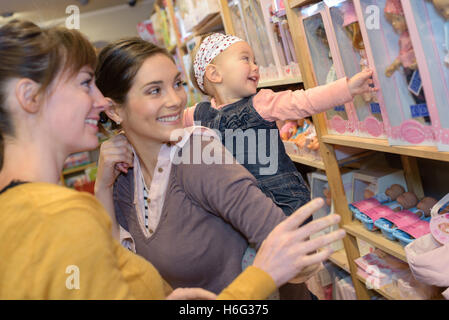 Mère et fille avec des forfaits en magasin de jouets Banque D'Images