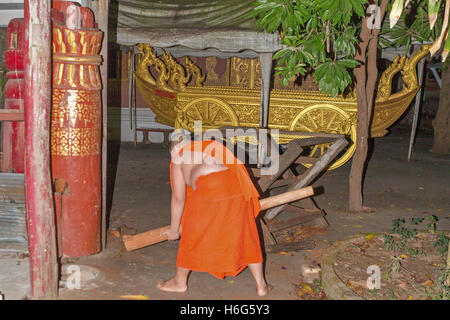 Frappant cylindre en bois creux, appelant les moines bouddhistes pour Tak Bat matin alms donnant cérémonie, pour les moines bouddhistes, Luang Prabang, Laos Banque D'Images