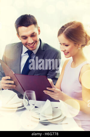 Smiling couple avec menu au restaurant Banque D'Images