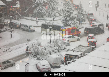 VSAV pompiers ambulance faire son chemin à travers les routes engorgée à Courchevel 1850 au cours de l'automne la neige Banque D'Images