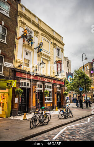 Peintres et décorateurs en rappel la façade de la Crown sur Monmouth Street, Londres, WC2 Banque D'Images